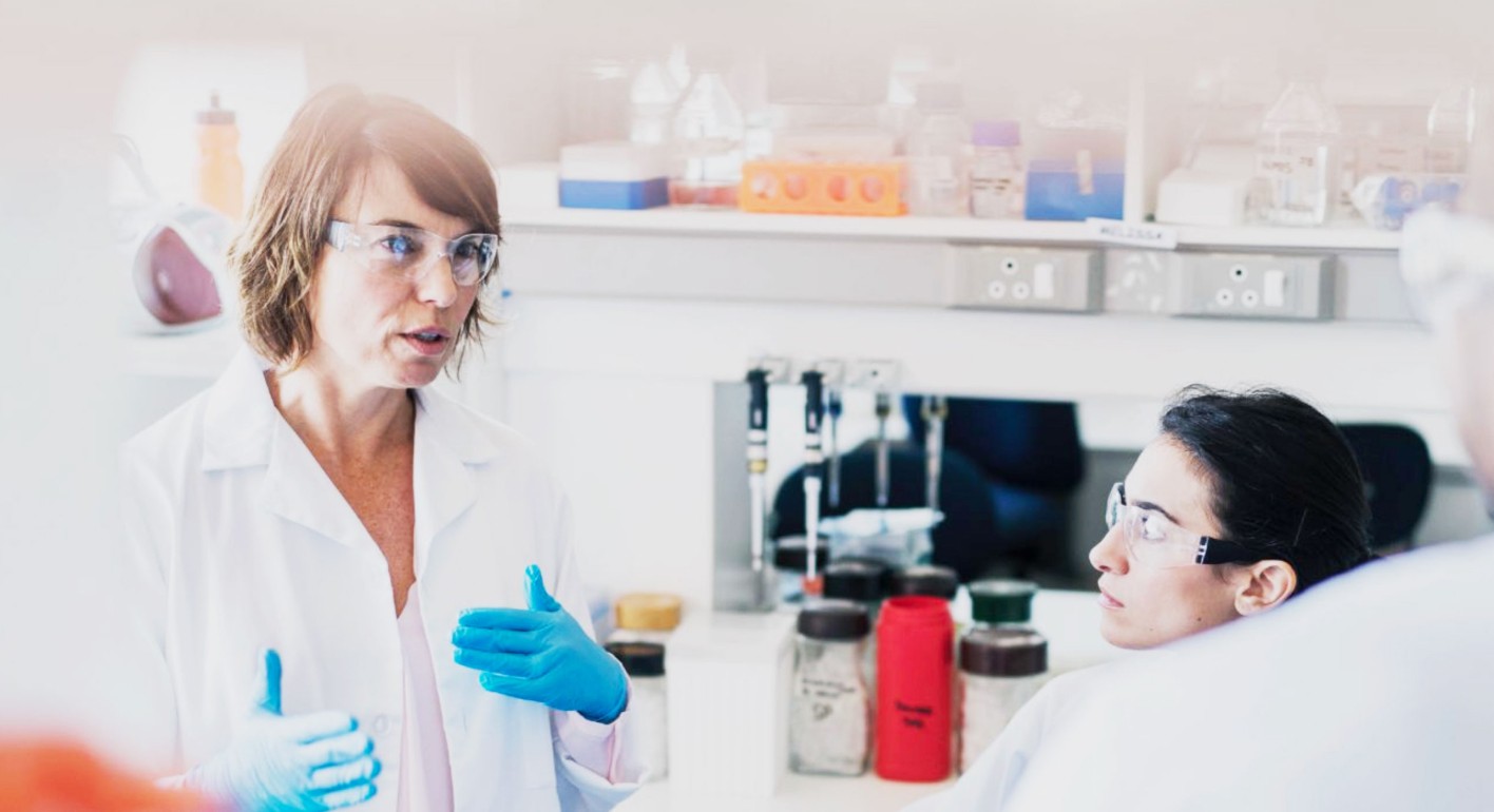 Female scientist speaking with colleagues in Laboratory