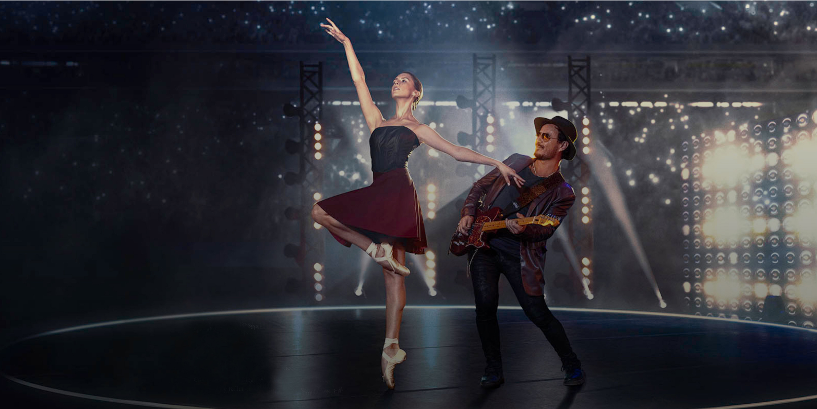 Chiara dances ballet in a deep burgundy skirted ballet dress with black bodice, next to a man playing an electric guitar. All around them, lights sparkle.