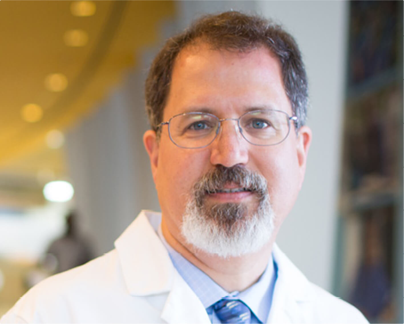 David Loeb, MD, looking toward the camera. He's wearing a lab coat, blue shirt and blue tie