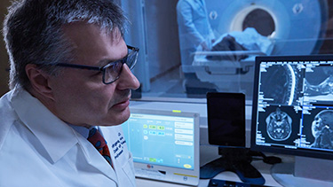 Doctor looking at MRI computer screen.