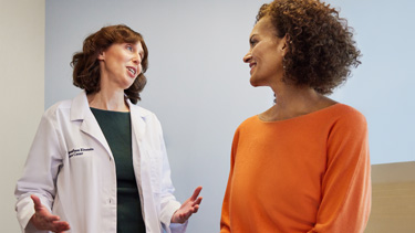 Woman doctor speaking with woman patient.