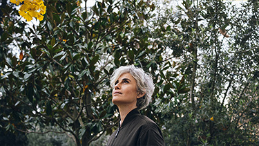Woman standing near trees.
