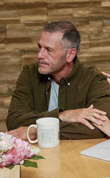 A man and a woman hold hands while concentrating on someone not pictured.