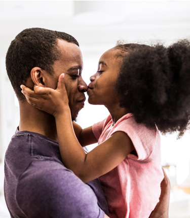 Father enjoying the kiss of his daughter.