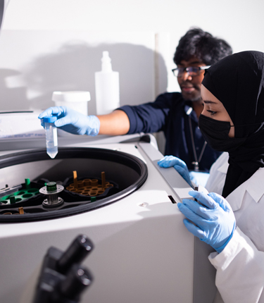 Two medical doctors working on a centrifugal machine